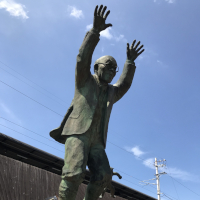 両手を挙げて飛び上がろうとしているお年寄りの銅像