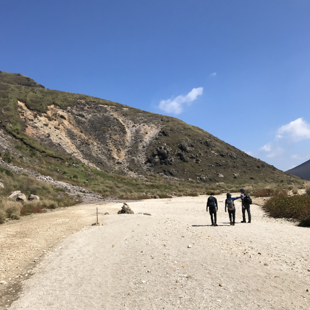 登山道を仲良さそうに歩く3人の男女